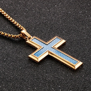 Detail of gold-framed cross pendant with blue carbon fiber inlay on box chain