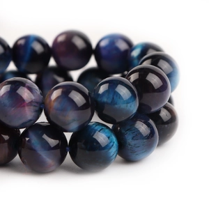 Macro shot of high-quality blue and purple tiger eye stone beads with cat eye effect