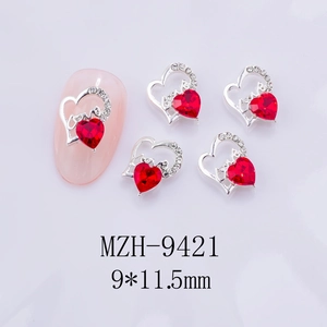 Vue macro de breloques à ongles en cœur évidé 3D avec pierres de zircon rouge et strass
