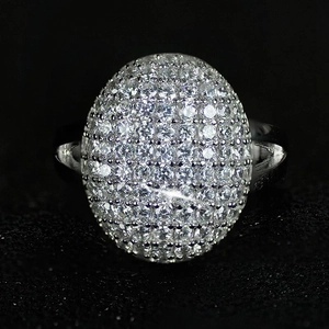 Macro shot of silver-tone oval ring featuring micro-pave 3A zircon stones on black background