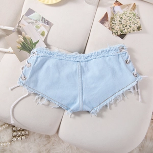 Dettaglio degli shorts in denim azzurro con lacci laterali e orlo sfilacciato