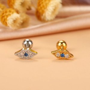 Makroaufnahme von lippenförmigen Steckern in Gold und Silber mit blauem Zirkon und Kugel