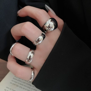 Detail of silver irregular geometric rings on hand with a professional fashion background