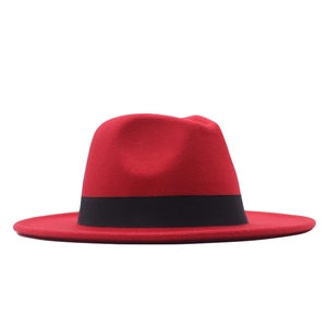 Detail of classic red wool fedora hat with wide brim and black ribbon decoration
