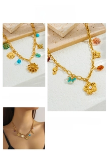 Close-up of gold chain necklace featuring vintage heart, butterfly and shell charms