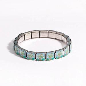 Close-up of stainless steel modular bracelet featuring floral enamel painted charms