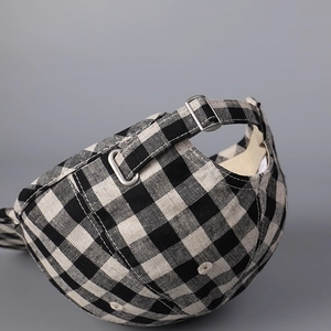 Macro shot of adjustable metal buckle and woven linen texture on a plaid baseball cap
