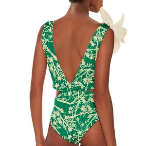 Detail of deep V backless swimsuit with 3D white flower on shoulder and floral print