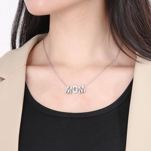 Gros plan du collier avec pendentif MOM en argent porté par un mannequin sur une chaîne