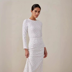 Elegant white floral slim-fit maxi dress with long sleeves and a sophisticated silhouette