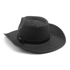 Detailed close-up of woven straw texture and black leather band on cowboy hat