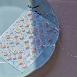 Detail of seashell and starfish nail art stickers with gold foil beach theme designs