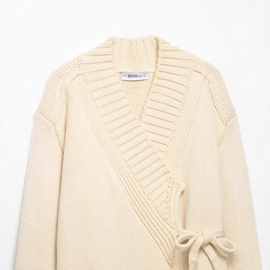 Chic beige knit cardigan with a V-neck wrap design and matching waist tie closure