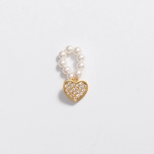 Close-up of pearl hoop earring with a sparkling gold heart-shaped gemstone pendant