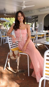 Detailed view of pink pleated camisole and matching high-waisted skirt texture