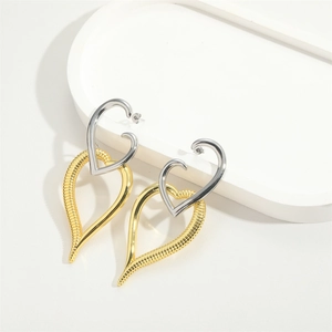 Detail shot of oversized interlocking heart pendant earrings in gold and silver finish