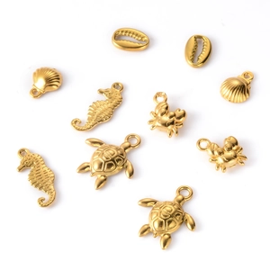 Flat lay of gold ocean charms including sea turtle and crab for jewelry making