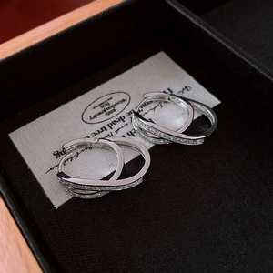Detail shot of double crossover S925 silver hoop earrings with white zircon stones