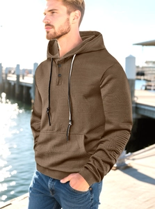 Detailed close-up of brown waffle textured men's hoodie with drawstring and button collar