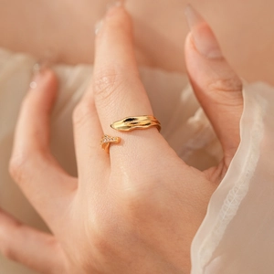 Gros plan d'une bague feuille asymétrique plaquée or avec cristaux sur le doigt