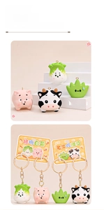 Detail showing cartoon resin pig and cow keychains with green cabbage charms