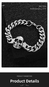 Close-up of retro silver skull chain bracelet on a black textured rock surface