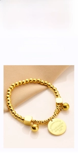 Detail of gold beaded bracelet featuring engraved Eternal Love and New York round tag