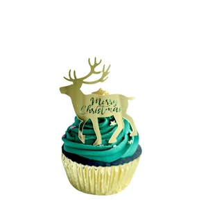 Golden Merry Christmas reindeer cupcake topper with laser-cut design on green frosting
