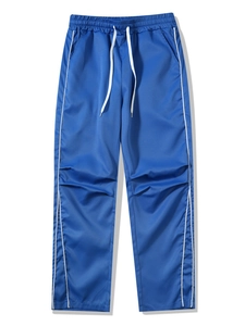 Detail of blue joggers featuring elastic drawstring waist and white side stripes