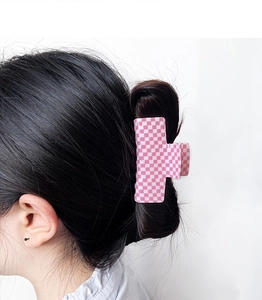 Pink and white checkerboard rectangle hair claw clip worn on a model's back hair
