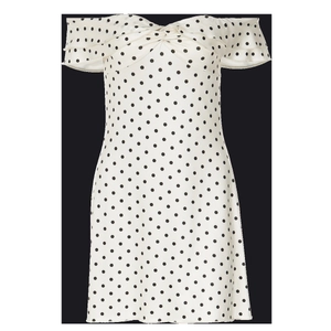 Close-up of white polka dot strapless dress with ruffle neckline and twist front detail