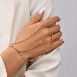 Detailed view of a gold chain bracelet and star ring combo on a model's hand