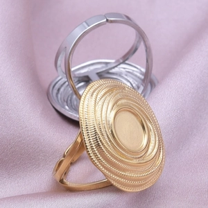 Macro detail of adjustable gold and silver DIY ring bases on pink silk background