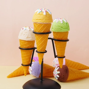 Five colorful PVC ice cream cone models with cream drizzle on a black metal display stand