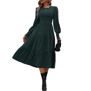Detail of smocked waist and tiered skirt on a dark green elegant midi dress