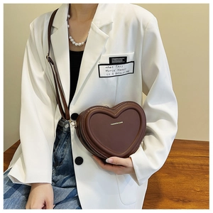 Dettaglio della borsa a tracolla a forma di cuore marrone scuro con scritte dorate