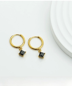 Macro shot of gold-plated stainless steel earrings with square black zircon inlay