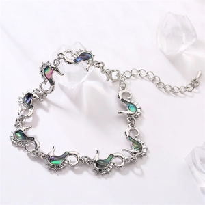 Macro shot of silver seahorse bracelet with abalone shell inlays and crystal accents