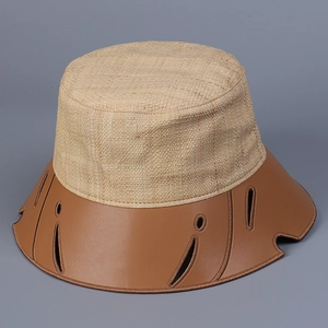 Dettaglio della trama in raffia e tesa in pelle marrone con ritagli sul cappello a secchiello