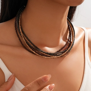 Close-up of layered bohemian beaded necklace in dark bronze and brown tones