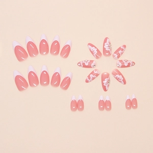 Detail of pink almond press-on nails with white French tips and crystal flower accents