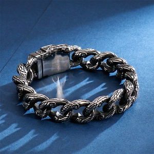 Close-up of vintage stainless steel chain bracelet with intricate skull pattern engraving