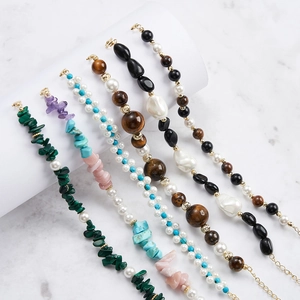 Macro view of assorted faceted gemstone bracelets with gold lobster clasps and extenders