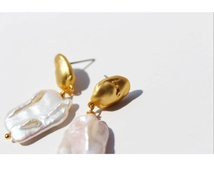 Close-up of vintage Baroque pearl earrings with textured gold plating and natural luster