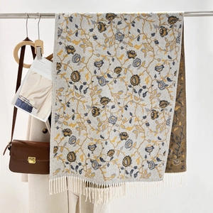 Ethnic jacquard floral scarf with tassels on beige coat with a stylish brown handbag