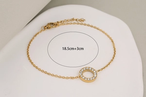 Detail view of gold stainless steel bracelet with crystal paved ring and size 18.5+3cm