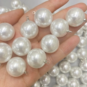 Detailopname van glanzende witte imitatieparels met zilverkleurige metalen ophangringen