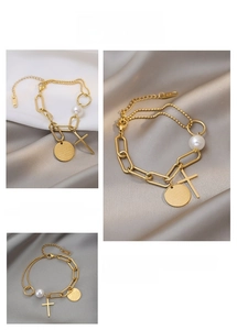 Detail of gold titanium steel bracelet featuring cross charm and pearl on silk background