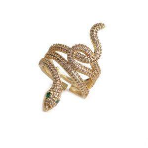 Detail of adjustable gold snake ring with white zircon pave and green stone eyes