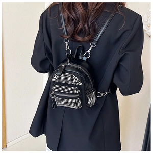 Vista posterior de una modelo con la mini mochila negra de diamantes de imitación y correas